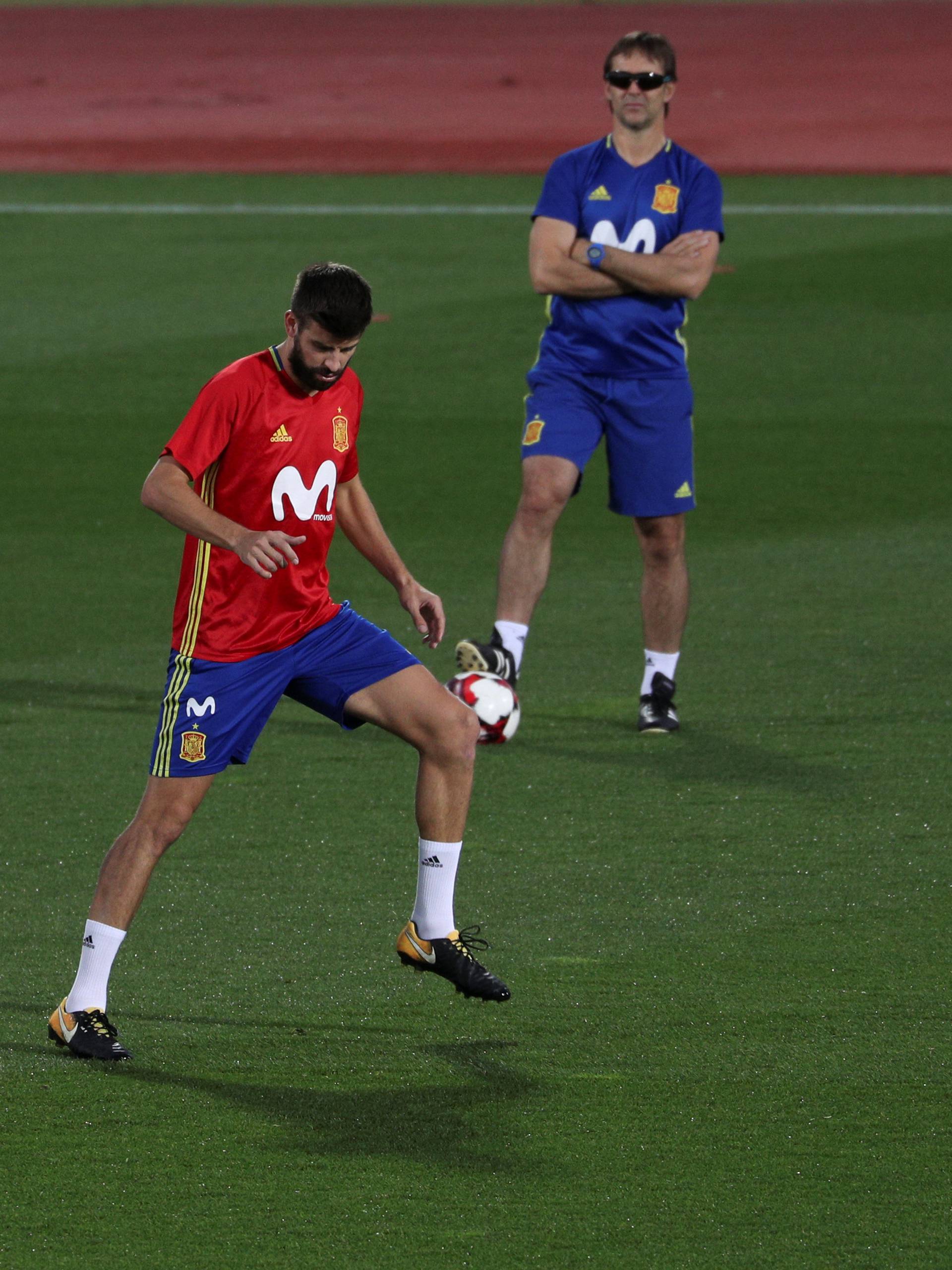 Spain's player Pique, exercises next to Alba and head coach Lopetegui during a training session in Las Rozas