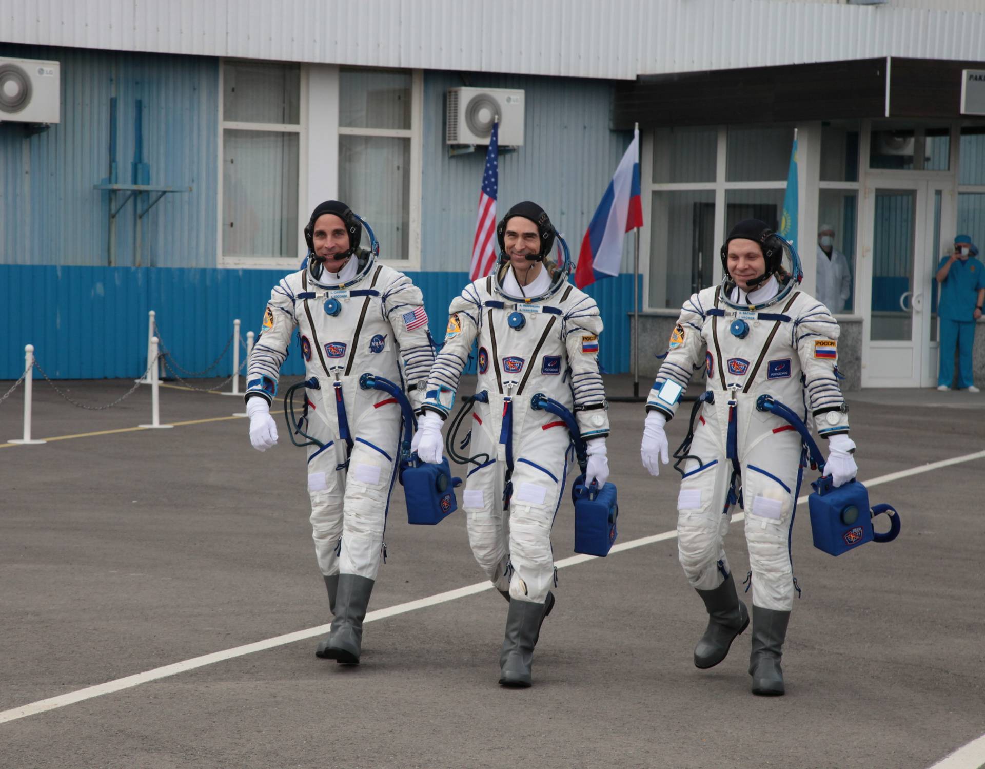 The International Space Station (ISS) crew members walk before leaving to board the Soyuz MS-16 spacecraft for the launch at the Baikonur Cosmodrome