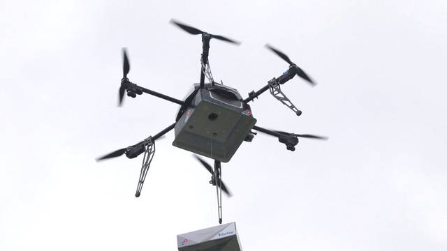 A delivery drone performs a test flight with a Domino's pizza box in Auckland, New Zealand