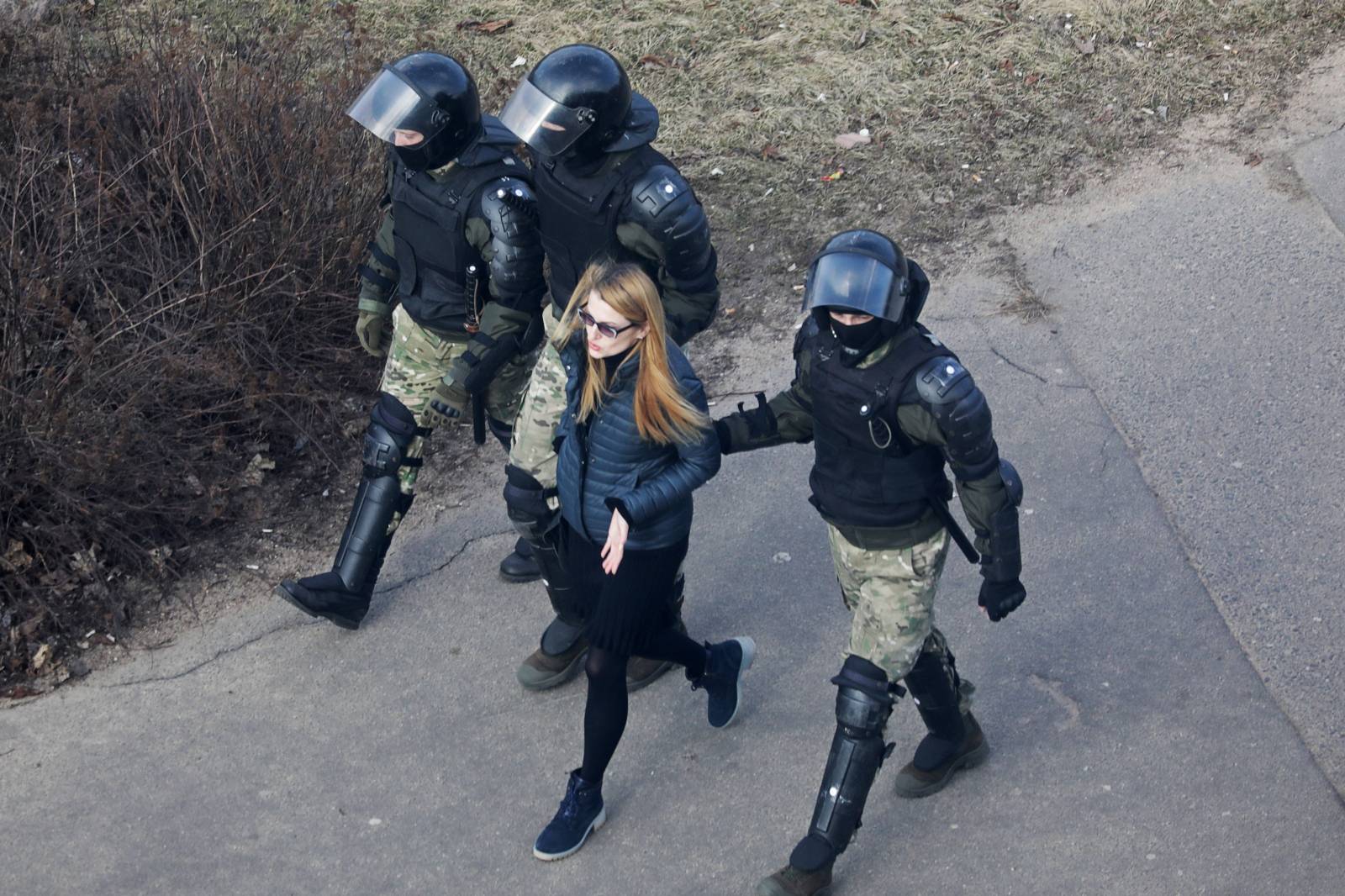 A woman is led away by law enforcement officers, as Belarusian opposition supporters gather for a rally in Minsk