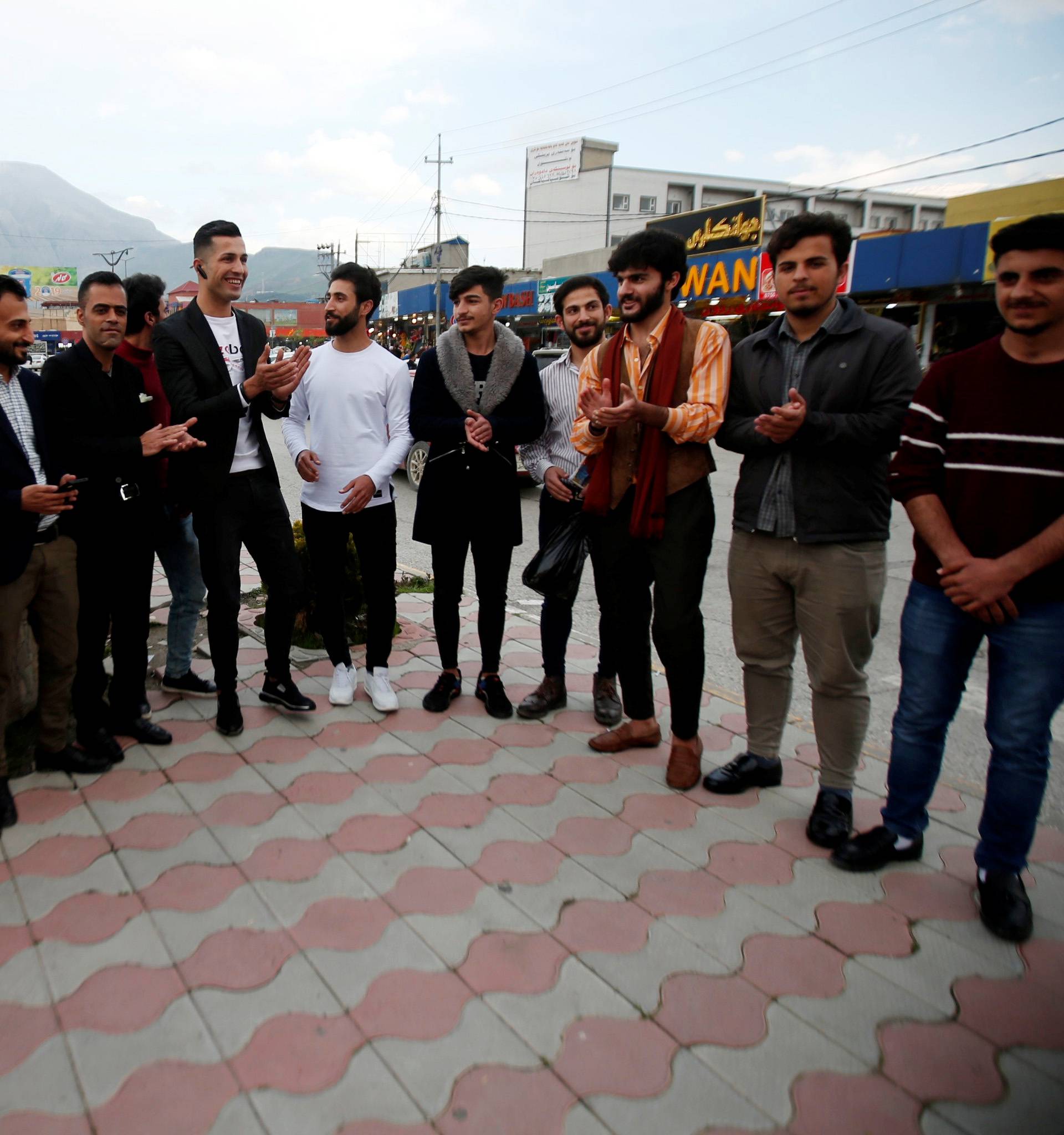 Biwar Abdullah, 25, an Iraqi Kurdish local footballer, who looks like the football player Cristiano Ronaldo, takes pictures with people in the district of Soran, northeast of Erbil