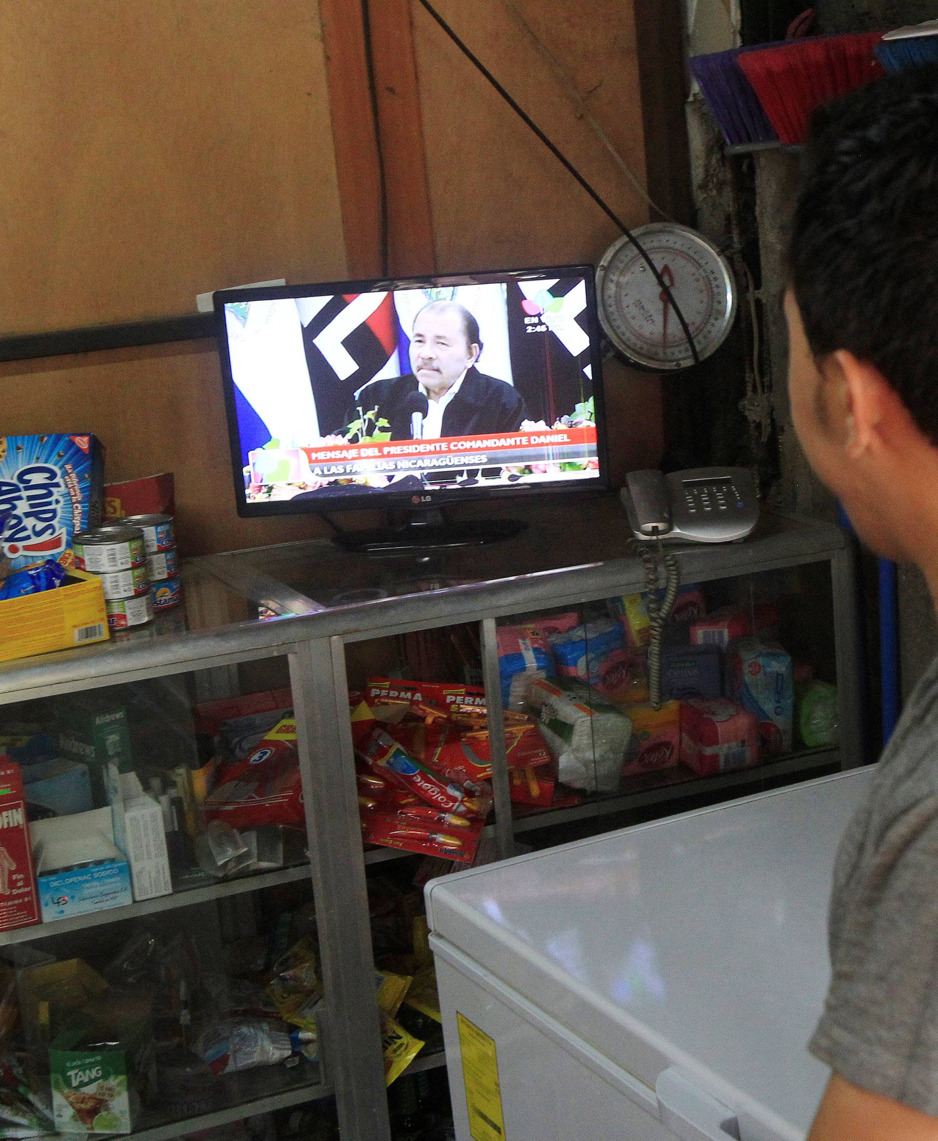 A man watches a transmission on TV of Nicaraguan President Daniel Ortega addressing the audience following protests over a reform to the pension plans of the INSS in Managua