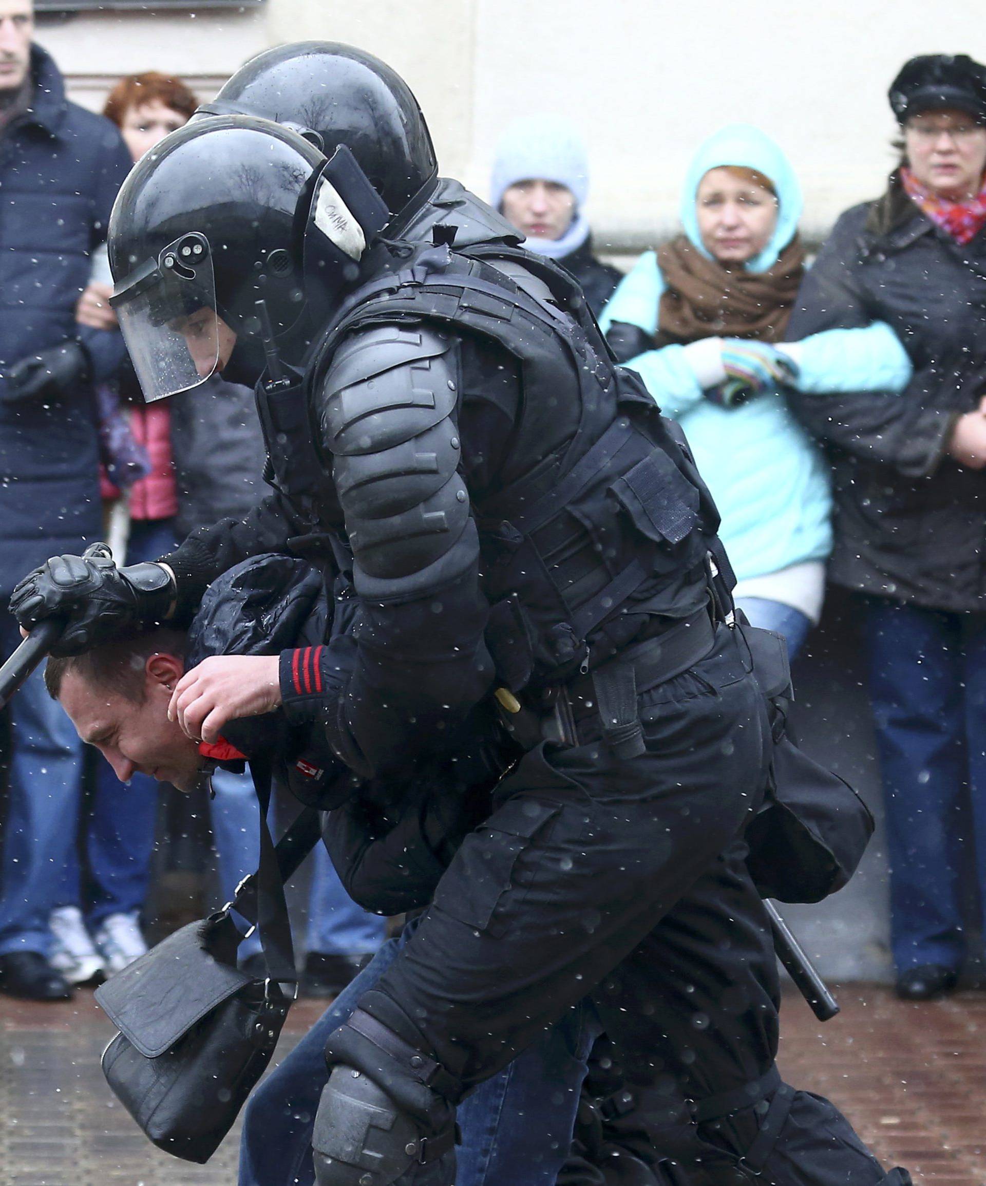 Law enforcement officers detain a man during a gathering which marks the anniversary of the proclamation of the Belarussian People's Republic in Minsk