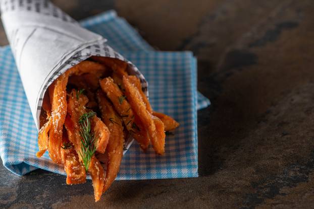 salted french fries with dill near cotton napkin on marble surface