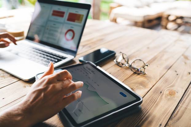 Hands,Using,Tablet,For,Real-time,Financial,Stats,Next,To,Open