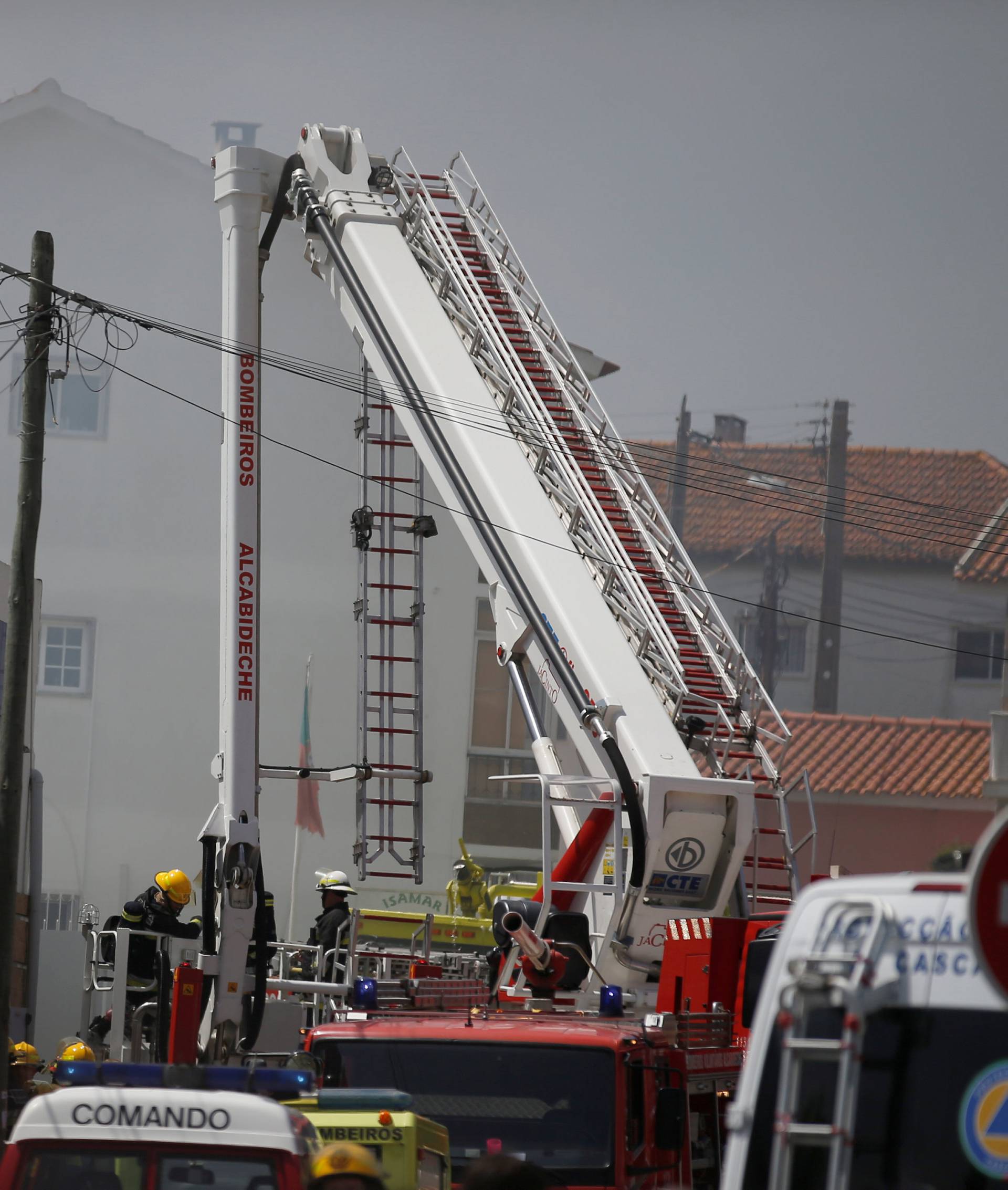 Firefighters work where a small airplane crashed near a supermarket in a residential area outside Lisbon