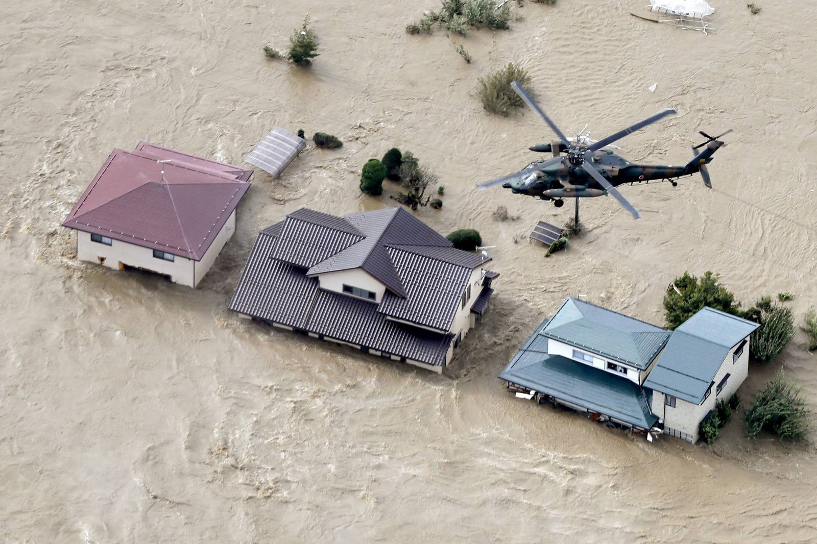 An aerial view shows a Japan Self-Defence Force helicopter flying over residential areas flooded by the Chikuma river following Typhoon Hagibis in Nagano