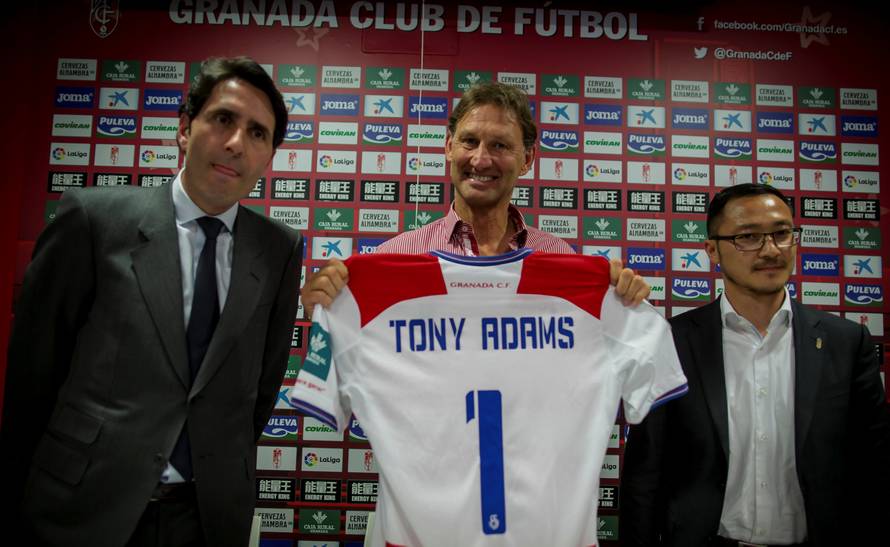 Former Arsenal and England captain Adams holds a Granada's jersey as he is flanked by VP Wang and board member Cuerva after being presented as new head coach in Granada
