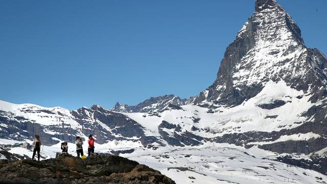 FILE PHOTO: Tourists take a picture in front of the Matterhorn mountain at the Gornergrat in Zermatt