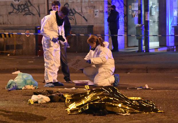 The body of Anis Amri, the suspect in the Berlin Christmas market truck attack, is seen covered with a thermal blanket next to Italian officers in a suburb of the northern Italian city of Milan