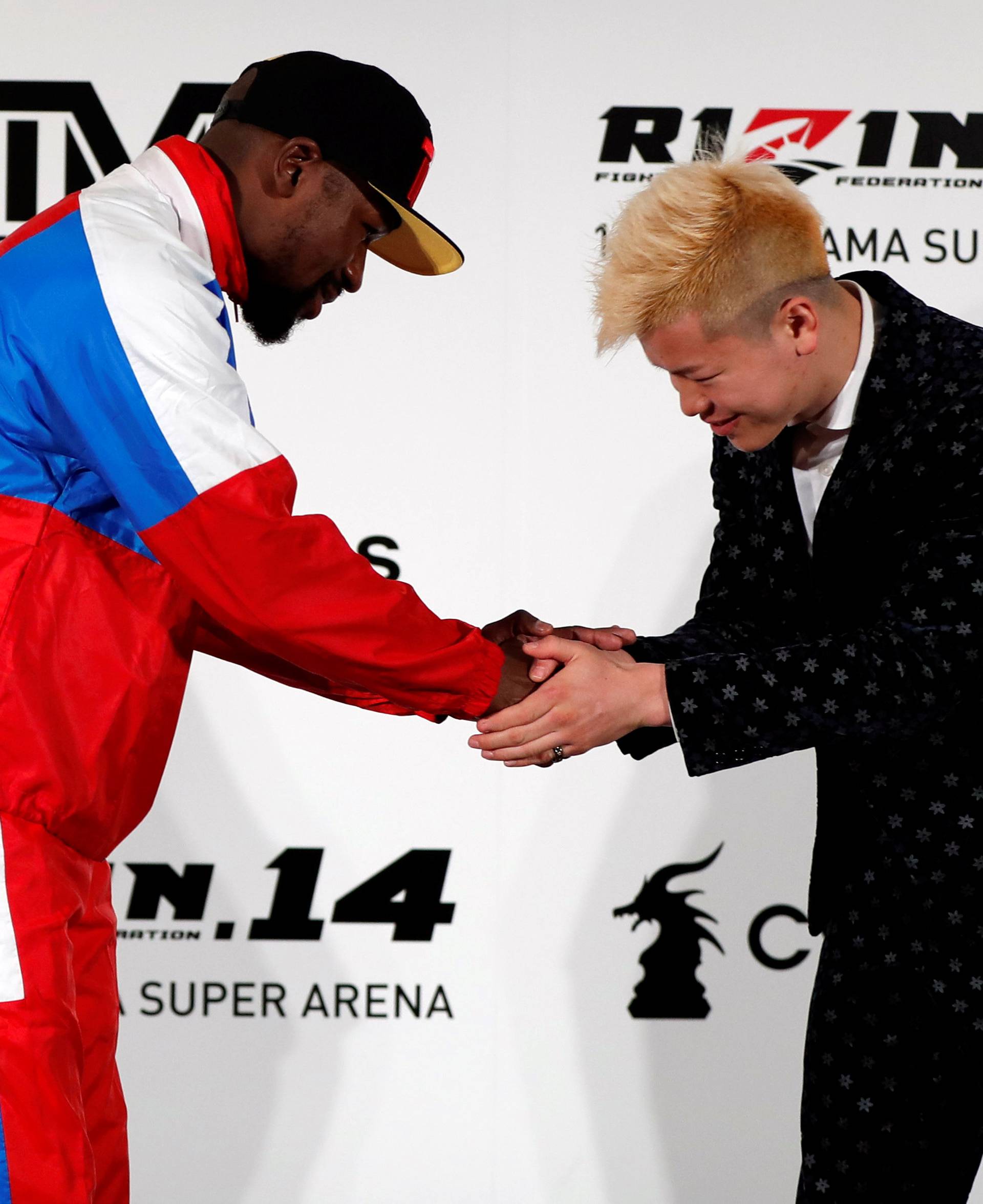 Boxer Floyd Mayweather Jr. of the U.S. shakes hands with his opponent Tenshin Nasukawa during a news conference inn Tokyo
