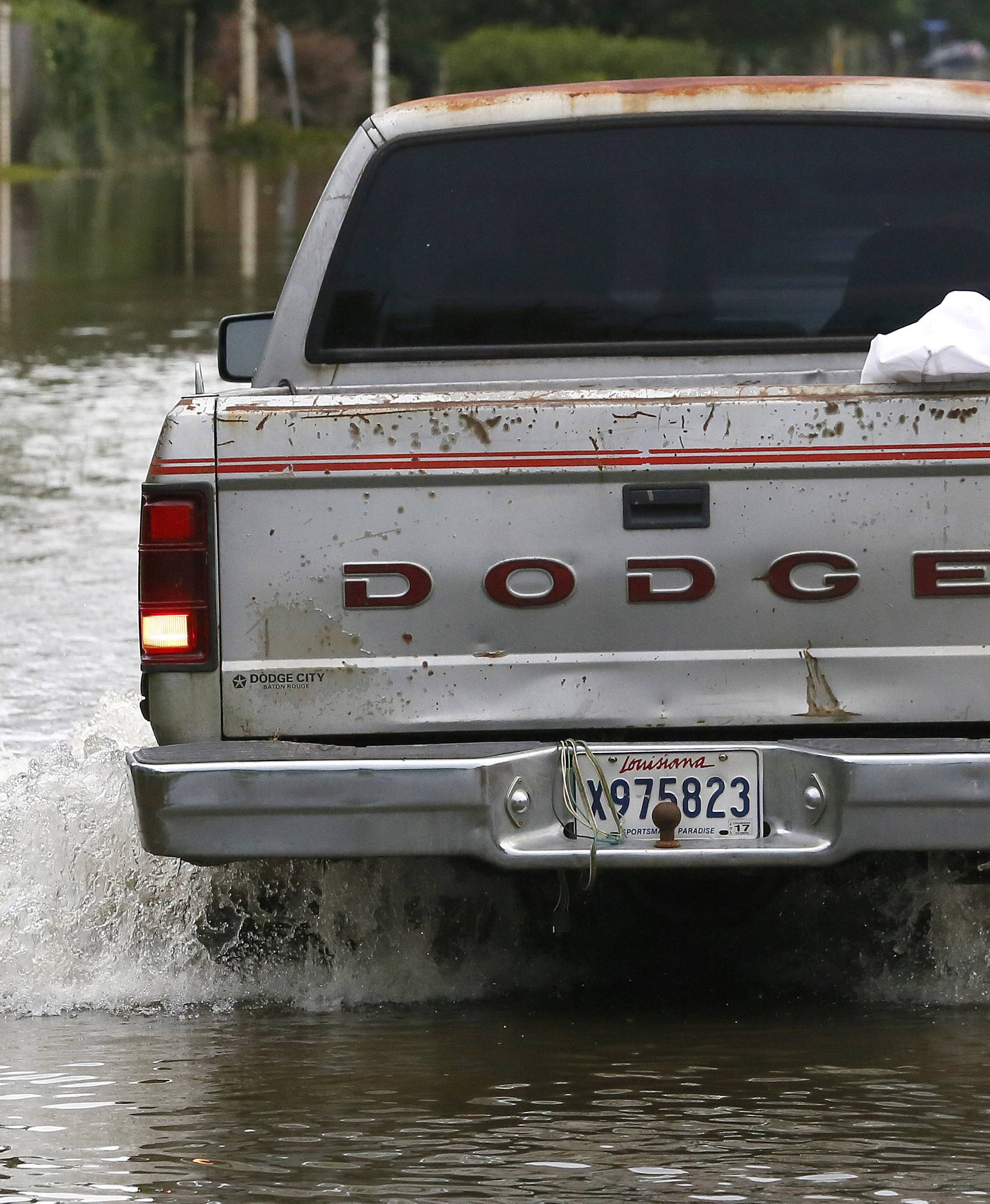 A vehicle backs up after attempting to drive through flood water in Prairieville, Louisiana