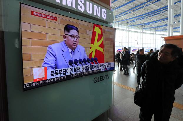 People watch a TV broadcasting a news report on North Korea