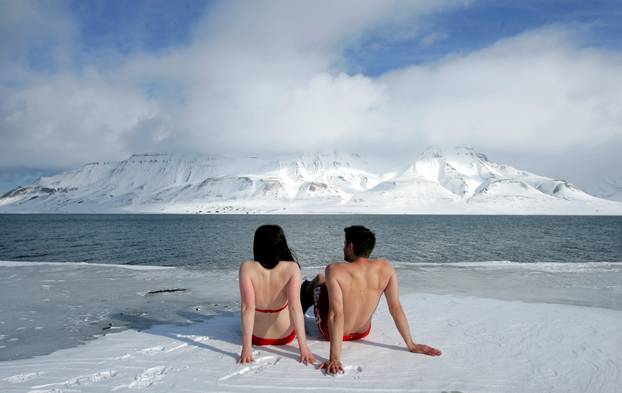 FILE PHOTO: Climate activists Lesley Butler and Rob Bell "sunbathe" on the edge of a frozen fjord in the Norwegian Arctic town of Longyearbyen