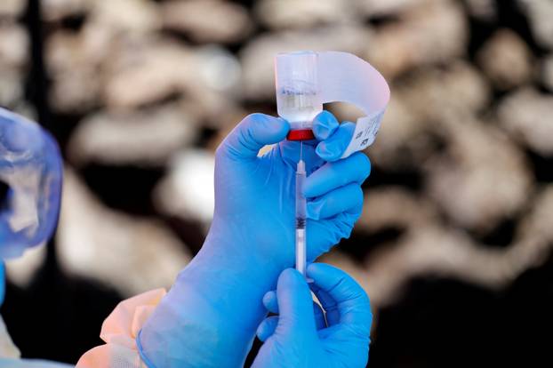 FILE PHOTO: A health worker fills a syringe with Ebola vaccine before injecting it to a patient, in Goma