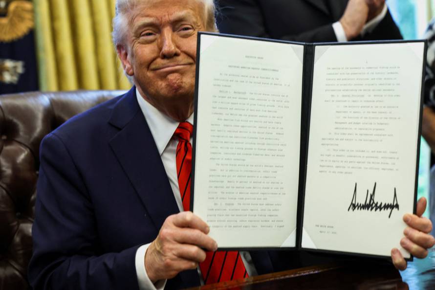 U.S. President Donald Trump signs executive orders in the Oval Office at the White House