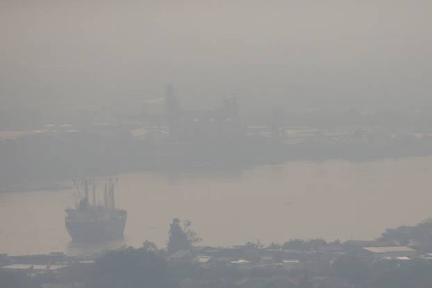 FILE PHOTO: A cargo ship is seen through air pollution along the Chao Phraya river in Bangkok