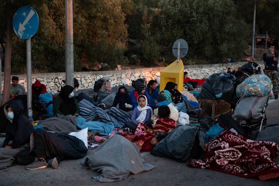 Refugees and migrants camp on a road following a fire at the Moria camp on the island of Lesbos