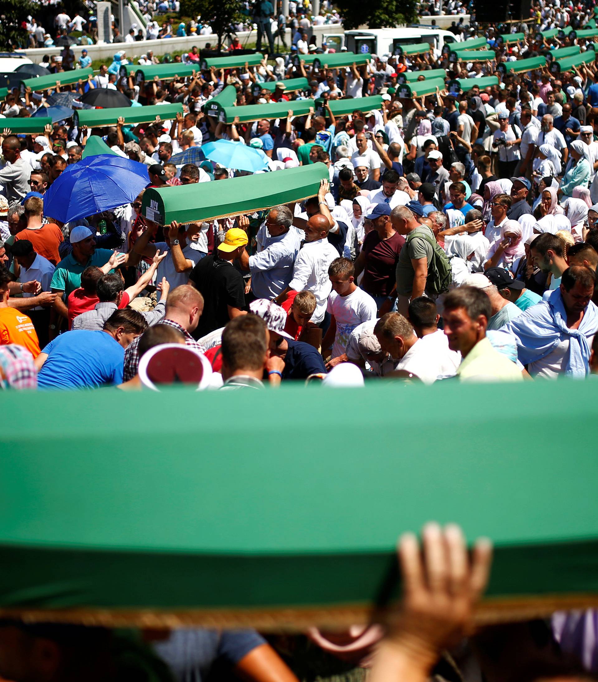 Muslim men carry coffins of their relatives, who are newly identified victims of the 1995 Srebrenica massacre, during mass funeral in Potocari near Srebrenica