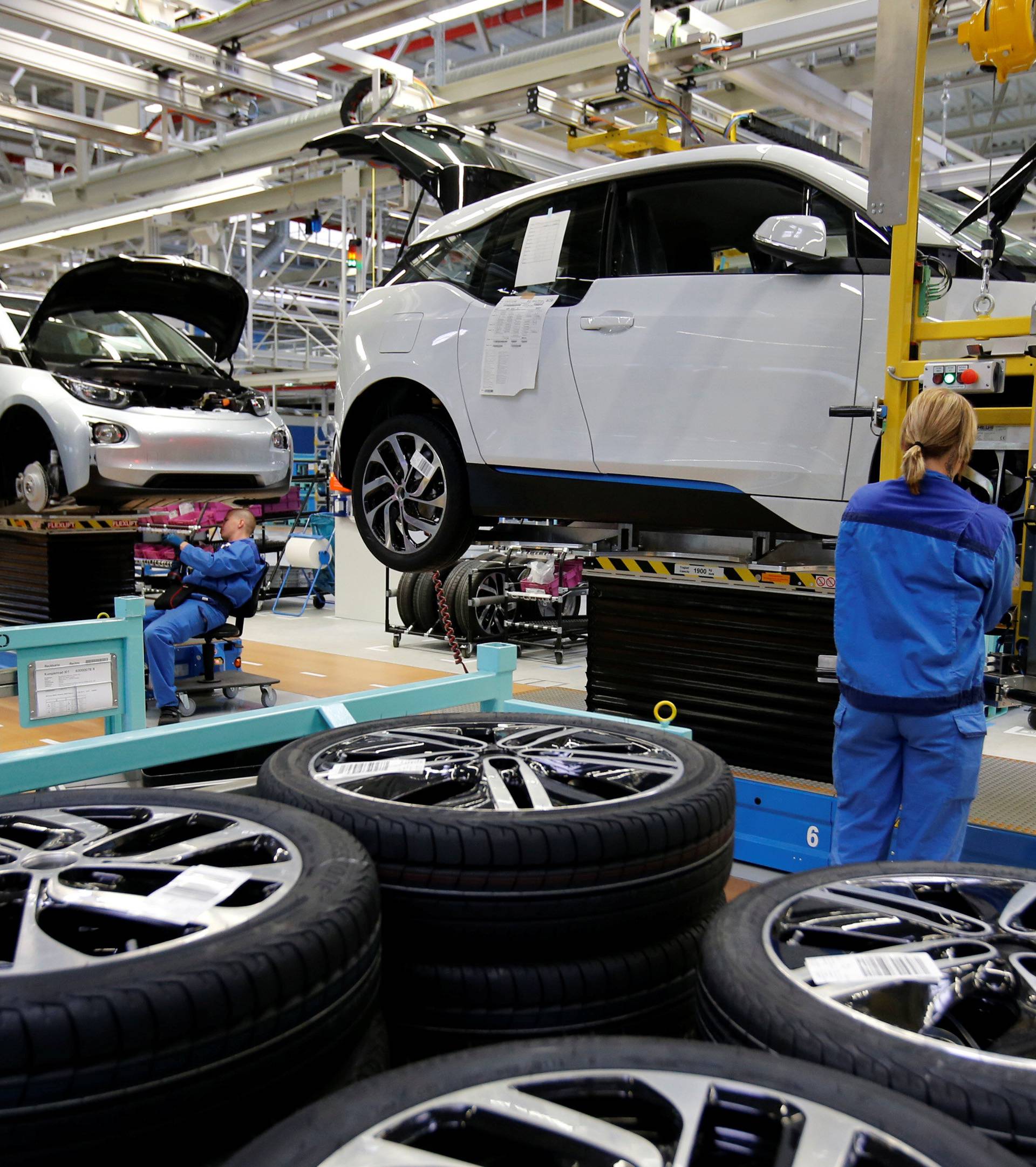 FILE PHOTO: A worker mounts a tyre at the serial production BMW i3 electric car in the BMW factory in Leipzig