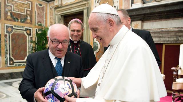 Pope Francis receives a football from Italian Football Federation President Carlo Tavecchio during a private audience at the Vatican