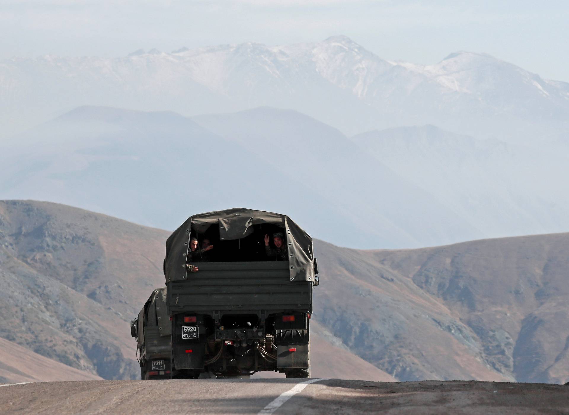 Ethnic Armenian soldiers ride in the back of a truck on the road that links Armenia and the region of Nagorno-Karabakh
