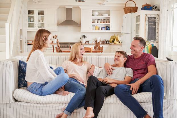 Family,With,Teenage,Children,Relaxing,On,Sofa,Together