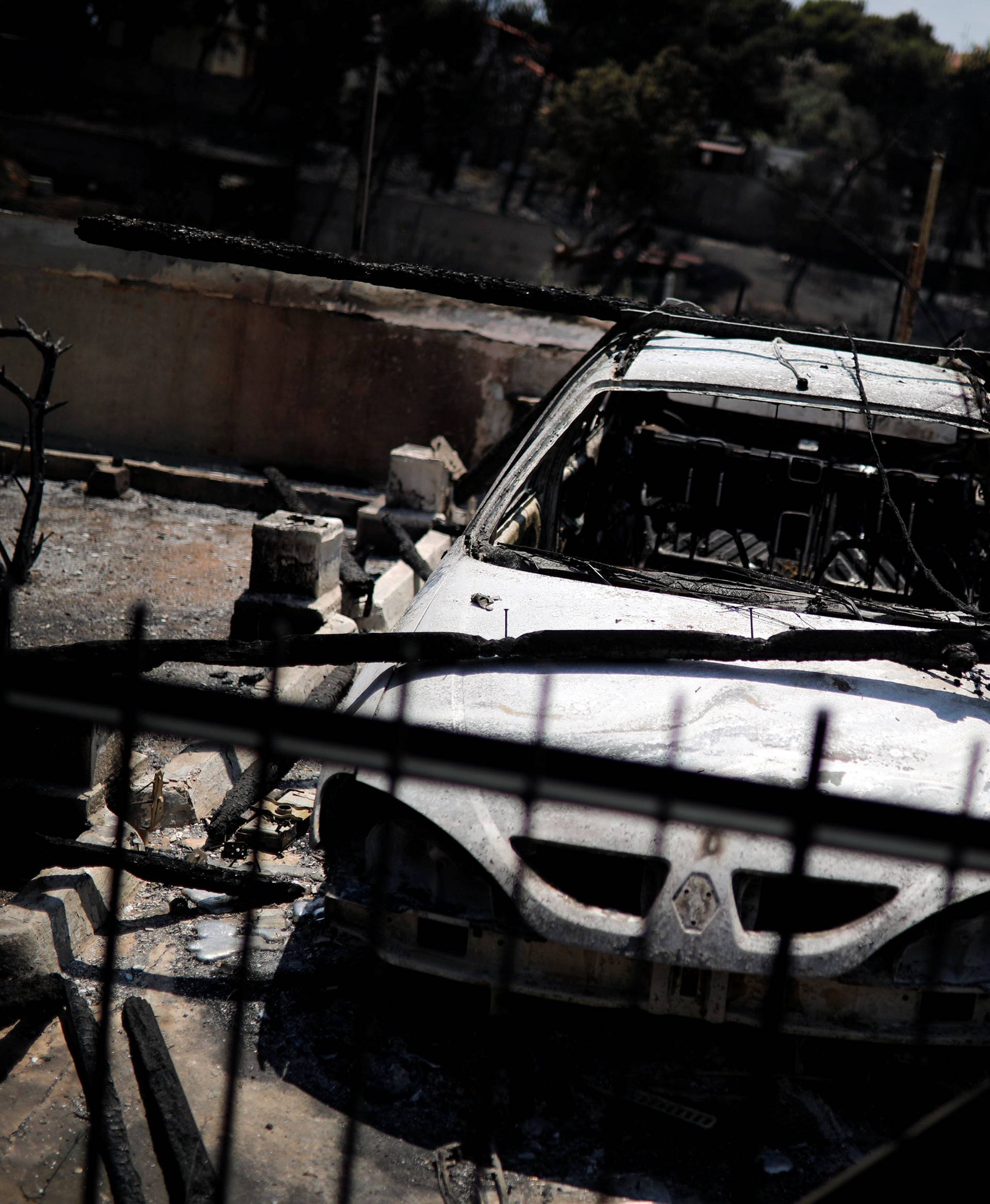 A destroyed car is seen following a wildfire in the village of Mati, near Athens