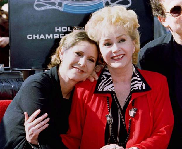 FILE PHOTO: Actress Debbie Reynolds poses with her daughter actress Carrie Fisher (L) after Reynolds star in the live theatre and stage category