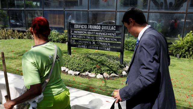 A man walk pass a company list showing the Mossack Fonseca law firm at the Arango Orillac Building in Panama City