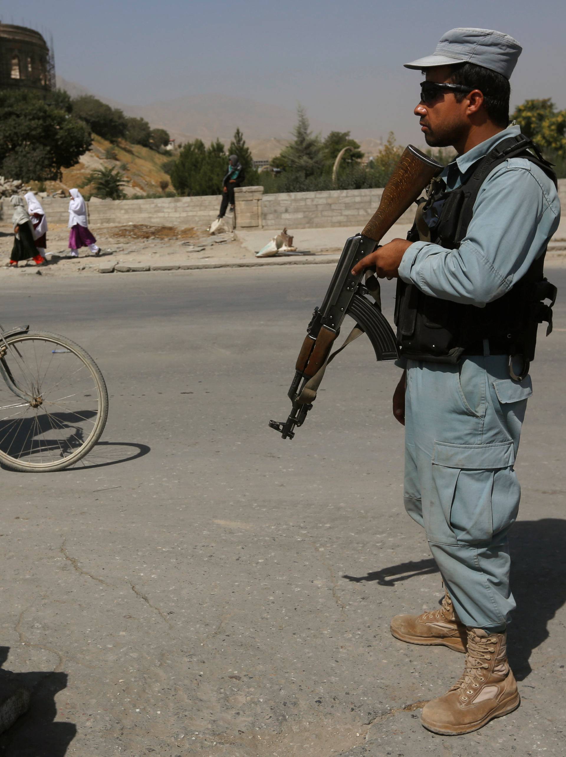 An Afghan policeman stands guard at a checkpoint near the site of kidnapping in Kabul