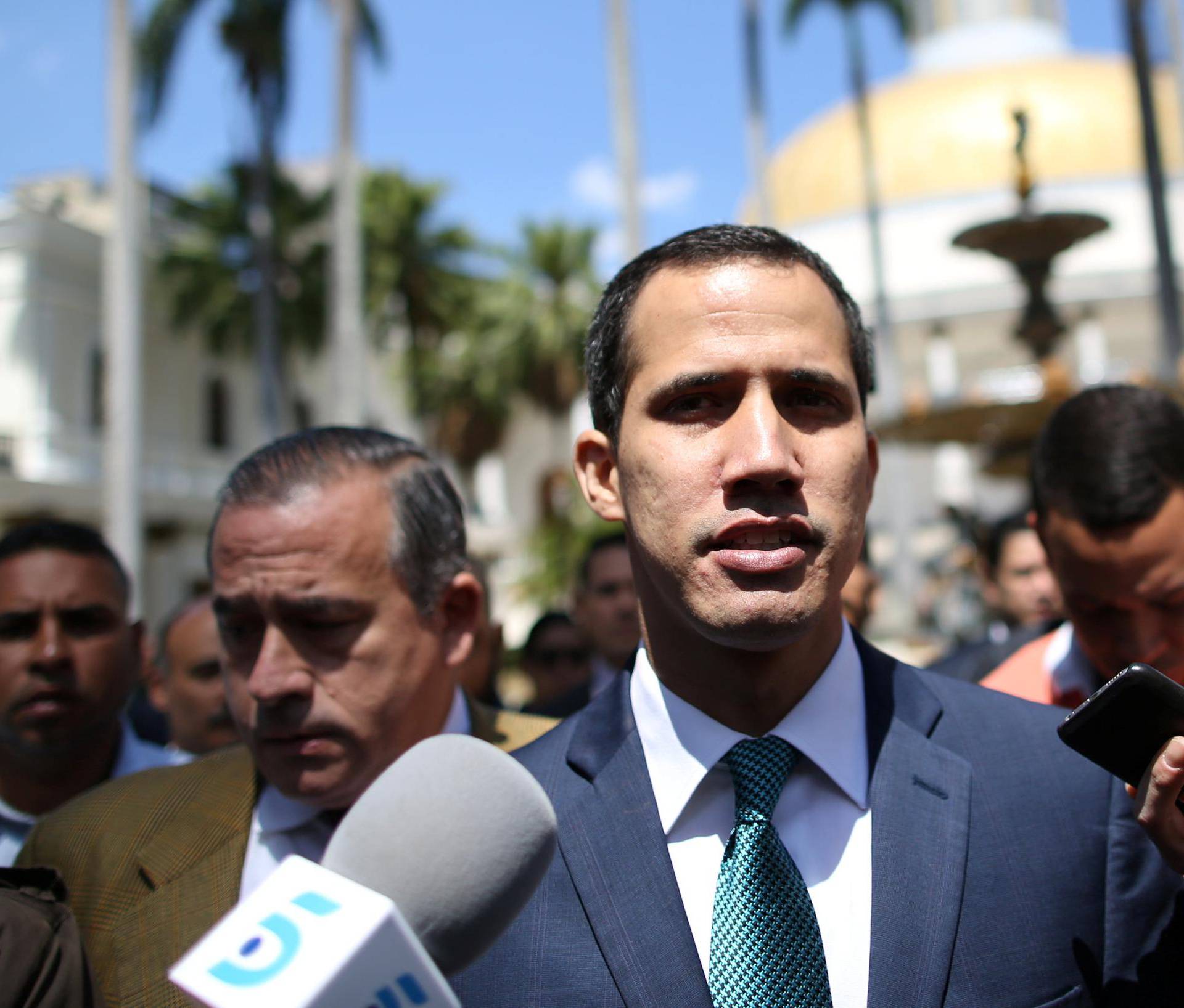 Venezuelan opposition leader Juan Guaido walks as he speaks to journalists before a news conference at the National Assembly in Caracas