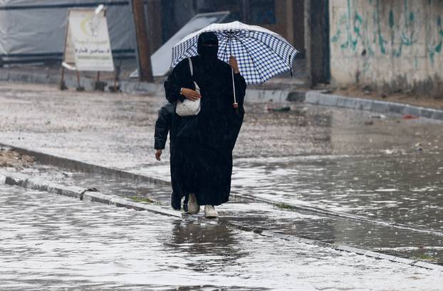 Displaced Palestinians shelter in a tent camp, on a rainy day in Nuseirat