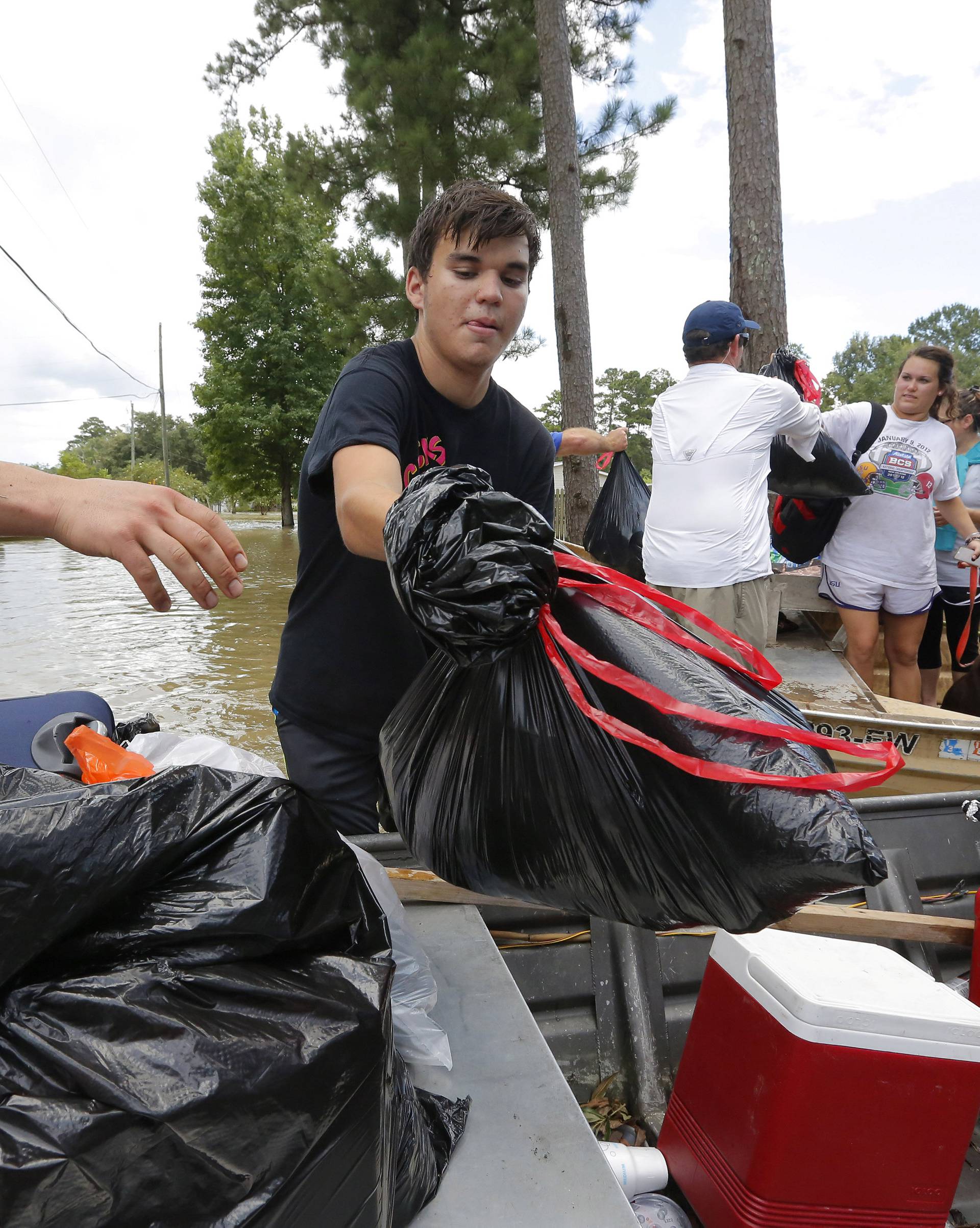 A resident transfers his belongings into a boat after being rescued in Ascension Parish