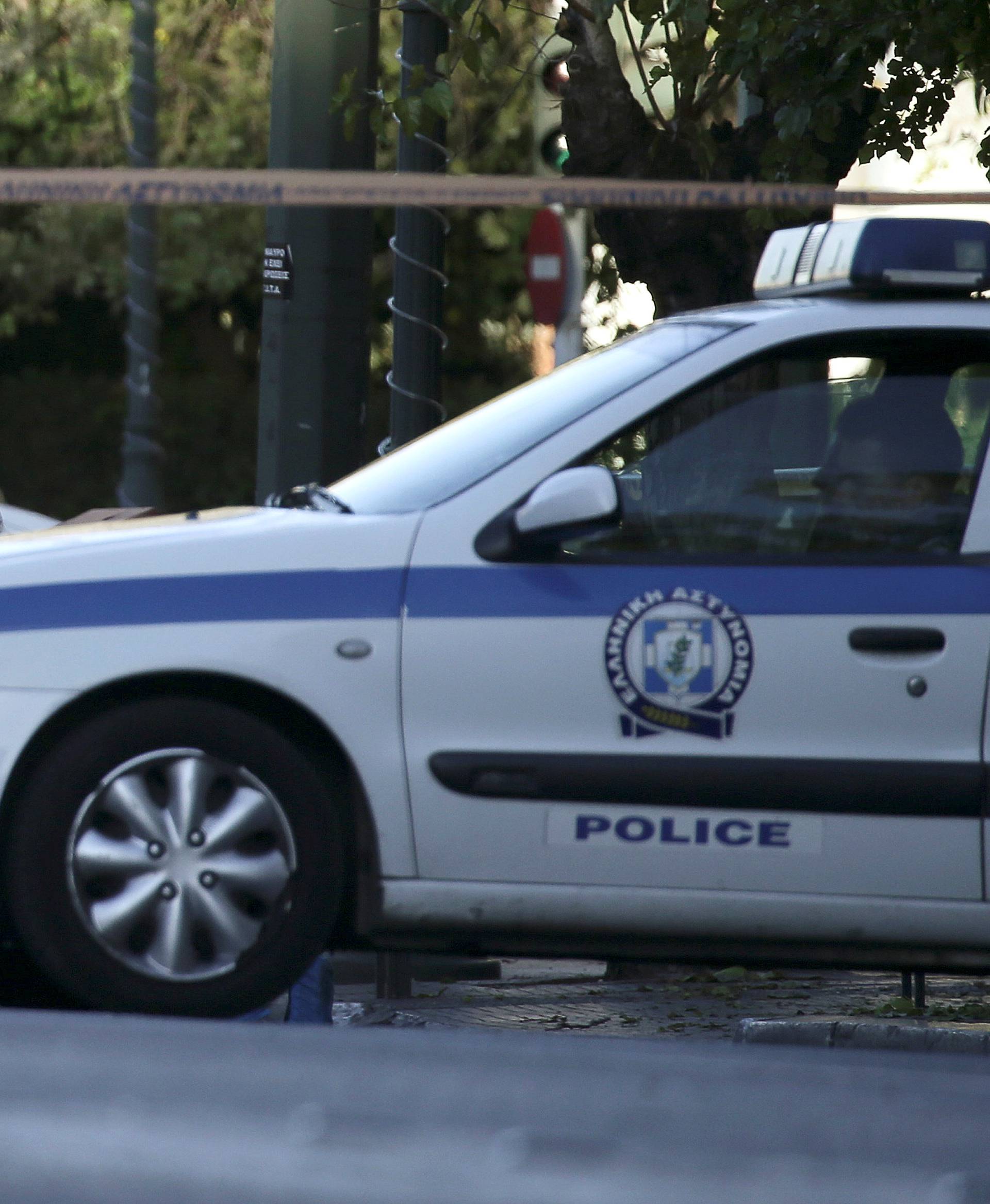 Forensics experts search for evidence outside the French embassy, where unidentified attackers threw an explosive device causing a small blast, in Athens