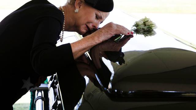 Cindy McCain lays her head on the casket of Sen. McCain during a burial service at the cemetery at the United States Naval Academy in Annapolis