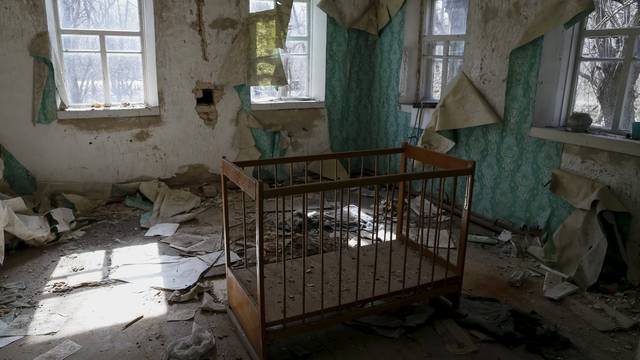 Ð baby cot is seen in a house in the abandoned village of Zalesye near the Chernobyl nuclear power plant