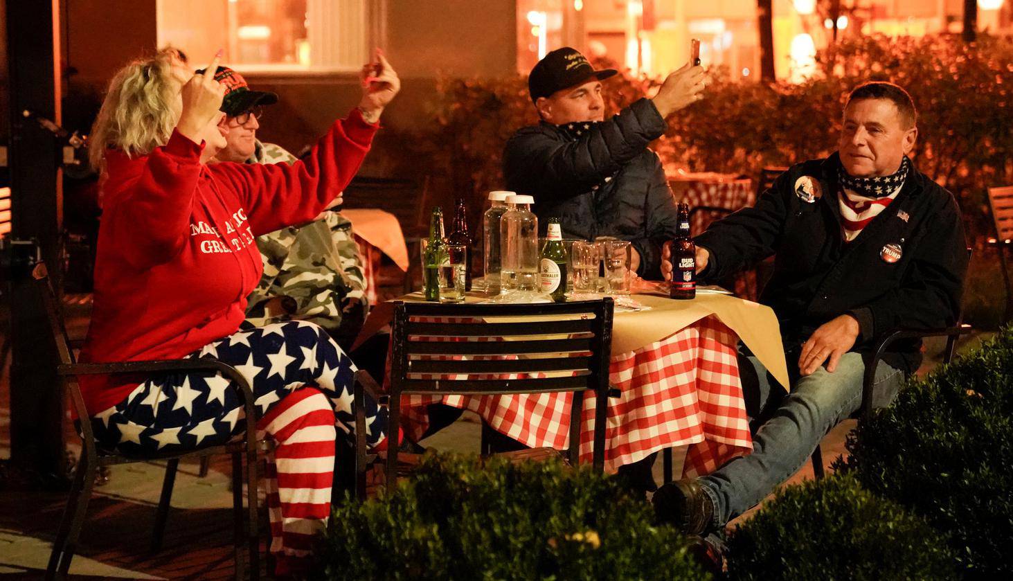 Supporters of U.S. President Donald Trump gesture towards anti-Trump protesters while dining near Black Lives Matter Plaza in Washington