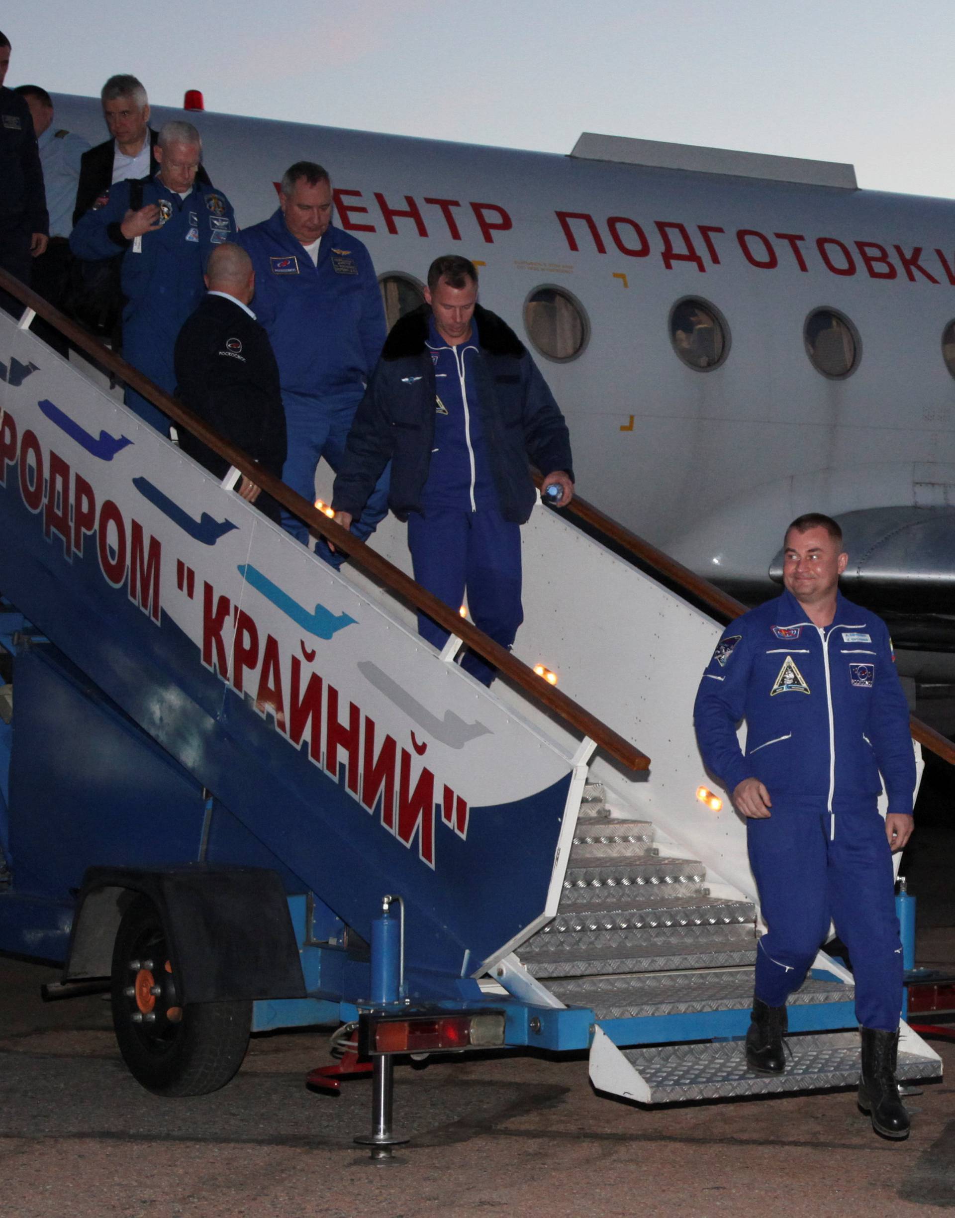 Russian cosmonaut Ovchinin and U.S. astronaut Hague arrive at Baikonur airport
