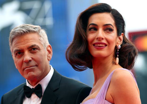 Actor and director George Clooney and his wife Amal pose during a red carpet event for the movie "Suburbicon" at the 74th Venice Film Festival in Venice, Italy