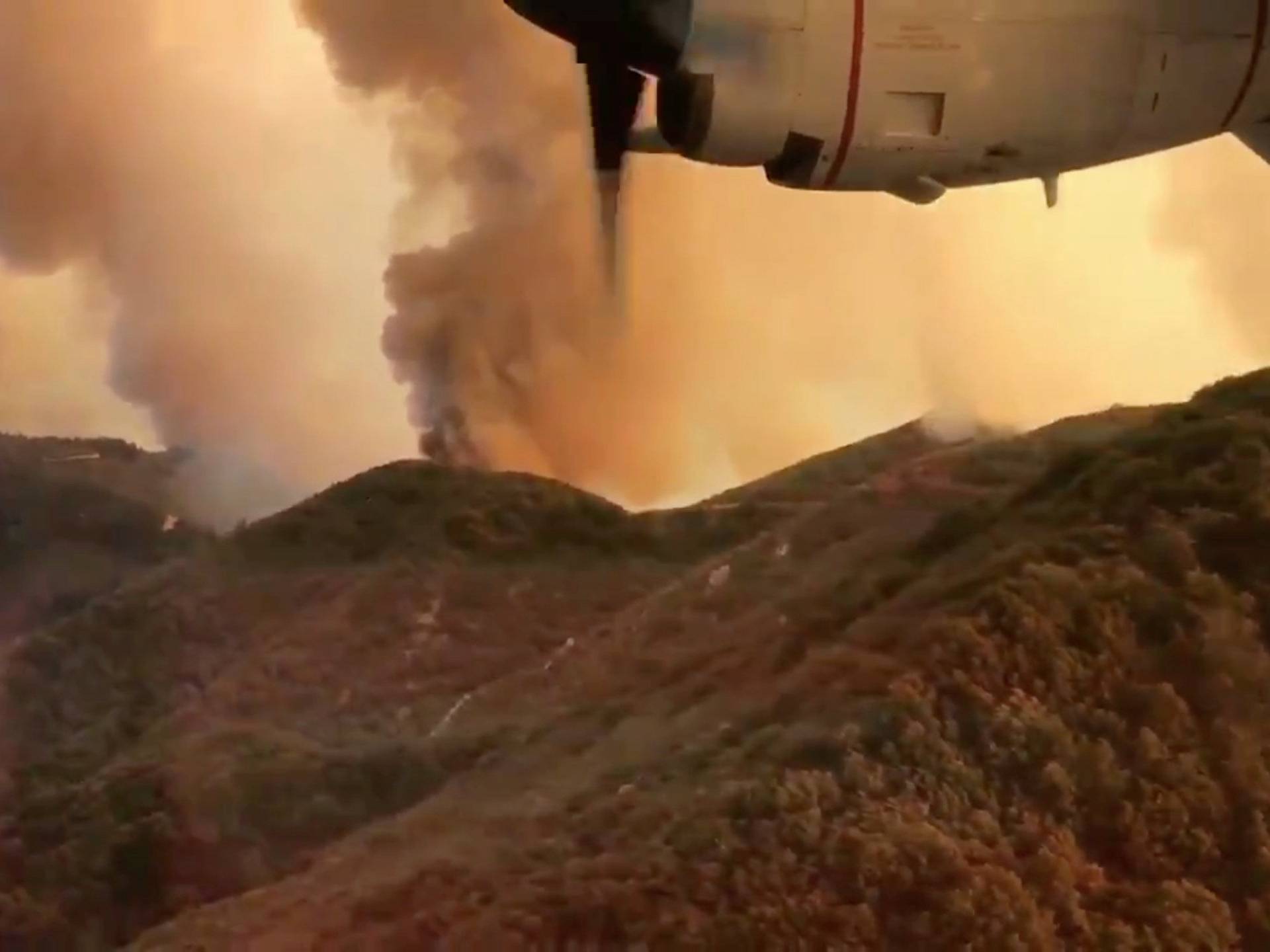 Aerial view of Trabuco Canyon as a tanker aircraft dumps load onto Holy Fire, California