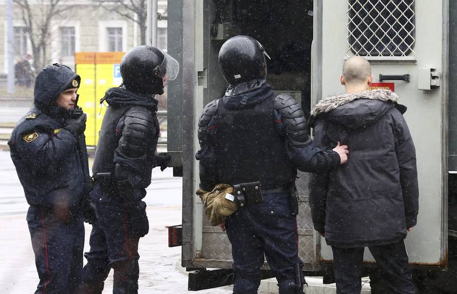 Law enforcement officers detain a man during a gathering which marks the anniversary of the proclamation of the Belarussian People's Republic in Minsk