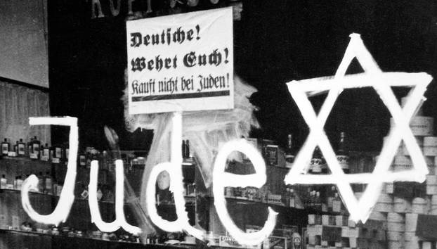 Germany: A Jewish-owned shop vandalized by Nazis with poster reading 'Germans Defend Yourselves - Don't Buy from Jews', 1938