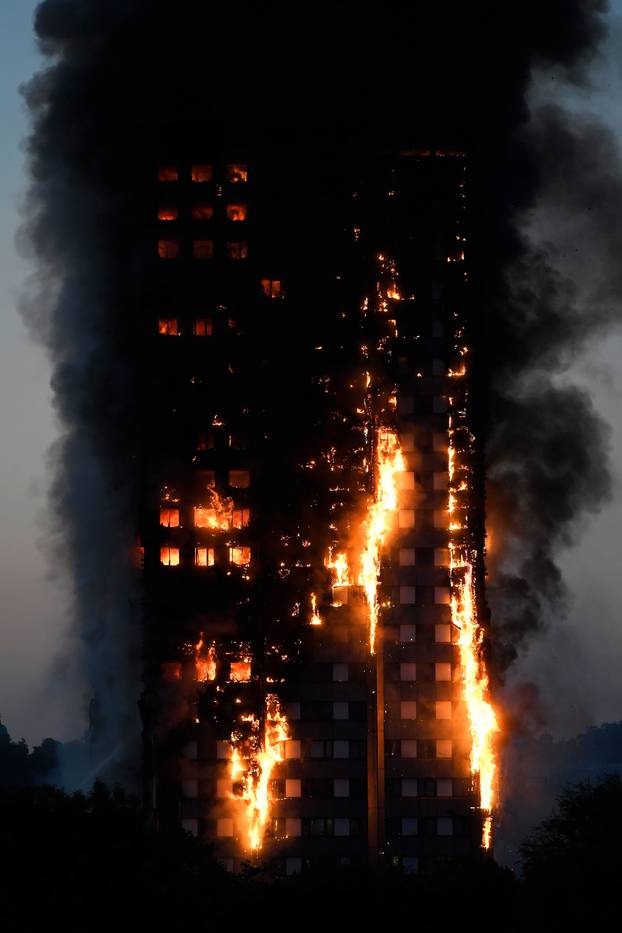 Flames and smoke billow as firefighters deal with a serious fire in a tower block at Latimer Road in West London