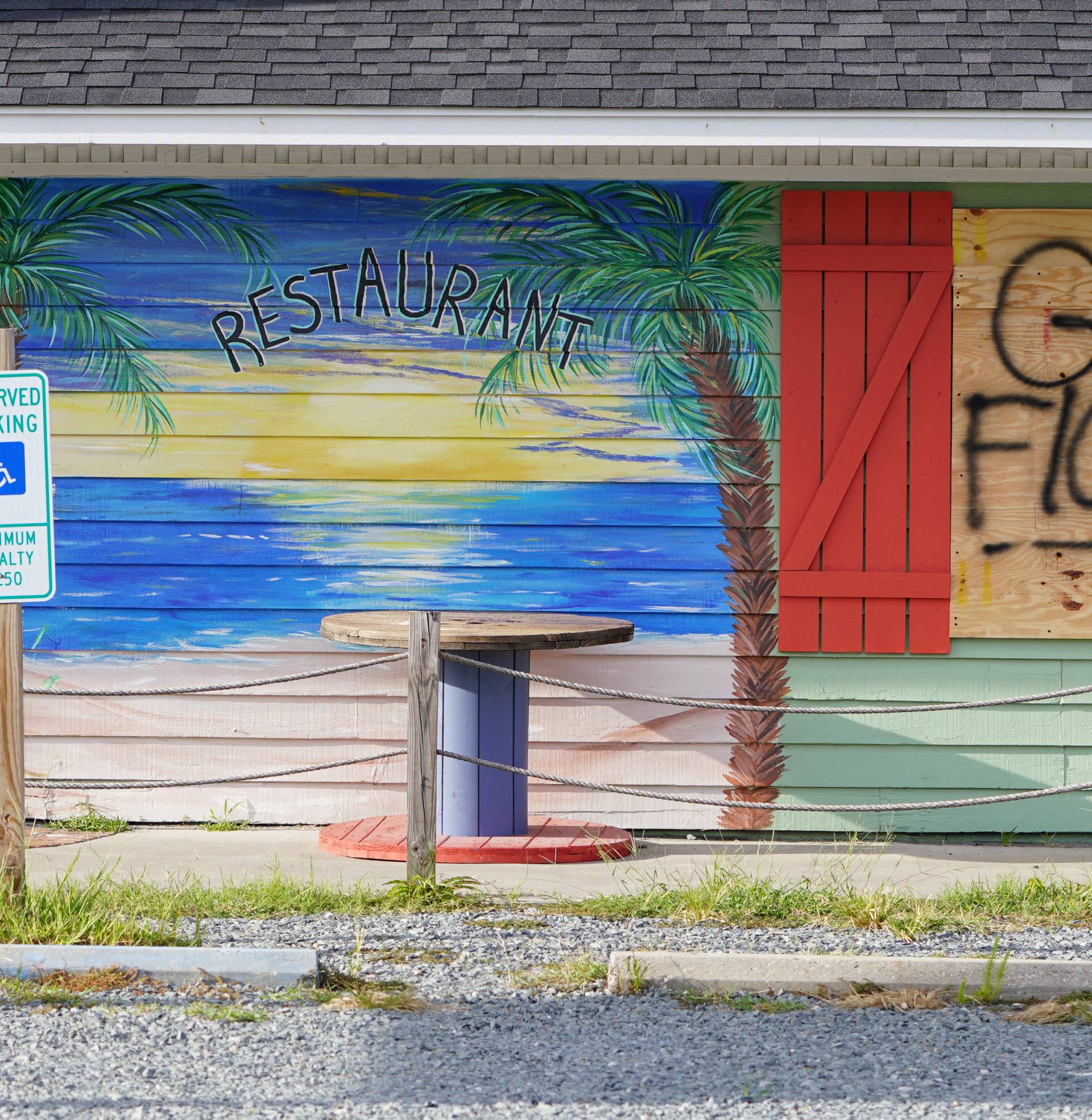 A sign is posted on a boarded up building before Hurricane Florence comes ashore on Oak Island