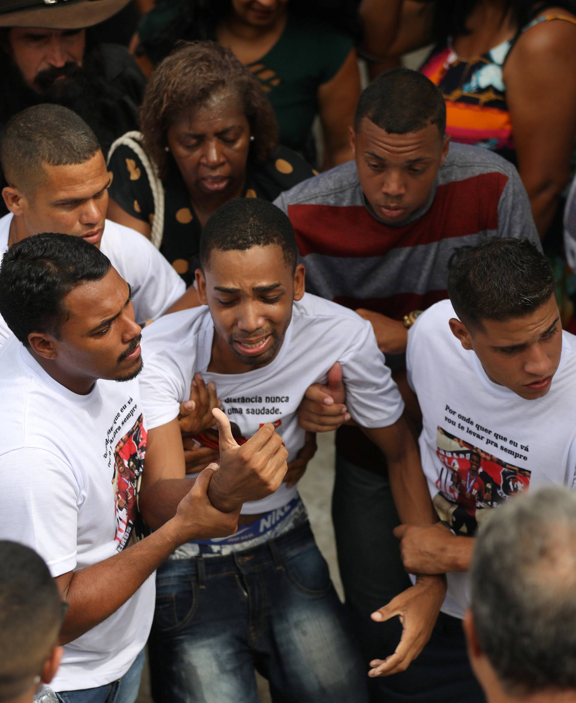 Relatives and friends of teenage soccer player Samuel Thomas de Souza Rosa, who died in the fire that swept through Flamengo's training ground react during his burial, in Rio de Janeiro