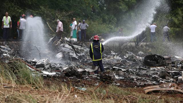 A fire fighter works in the wreckage of a Boeing 737 plane that crashed  in the agricultural area of Boyeros, some 20 km (12 miles) south of Havana on Friday shortly after taking off from Havana's main airport in Cuba