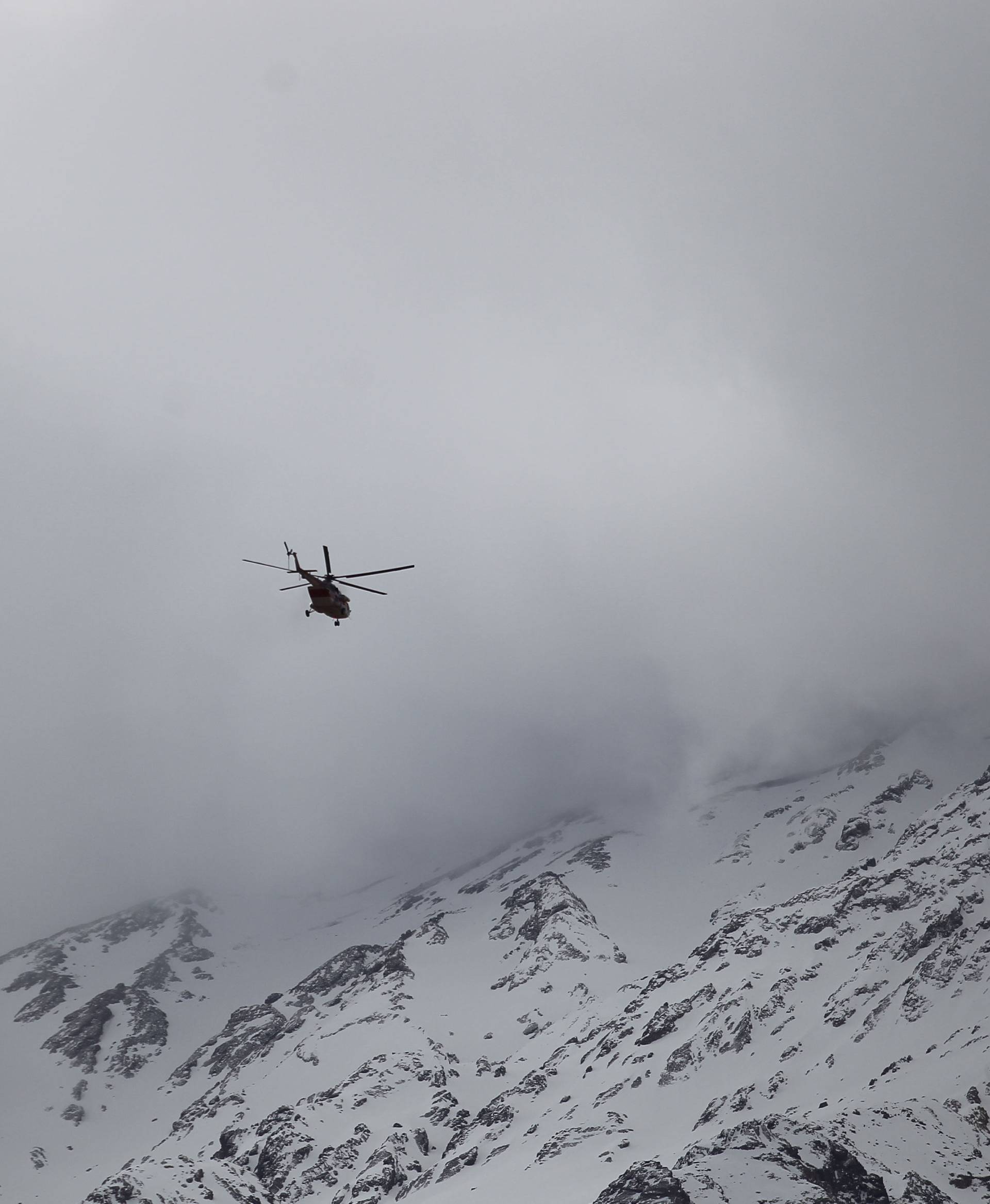 Emergency and rescue helicopter searches for the plane that crashed in a mountainous area of central Iran