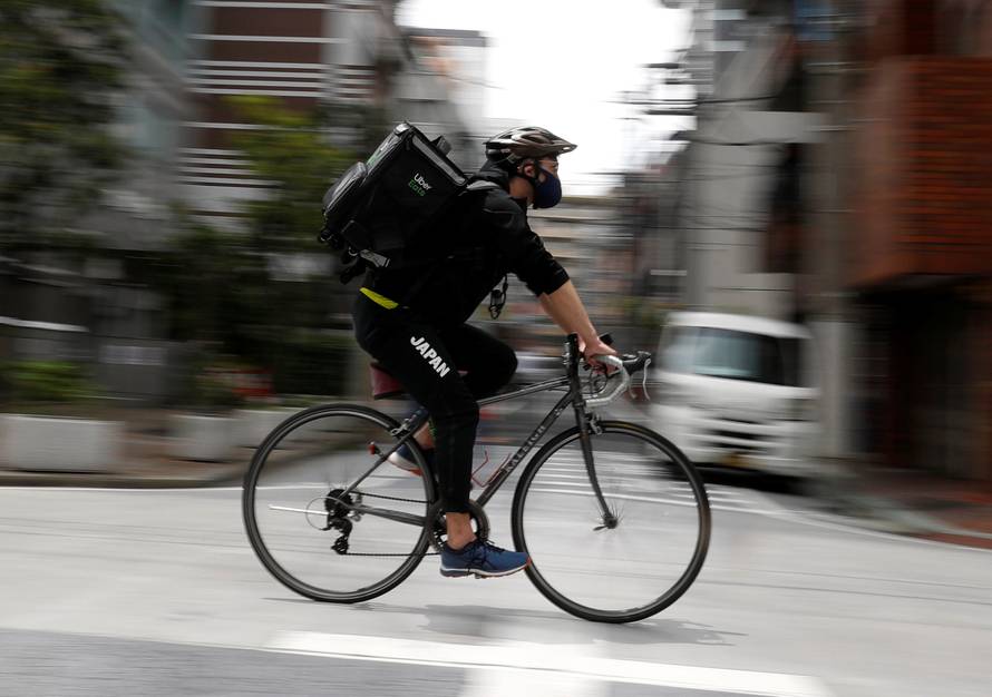 Japan's Olympic fencing medallist Ryo Miyake cycles as he works his part-time job as Uber Eats delivery person as the spread of the coronavirus disease (COVID-19) continues in Tokyo