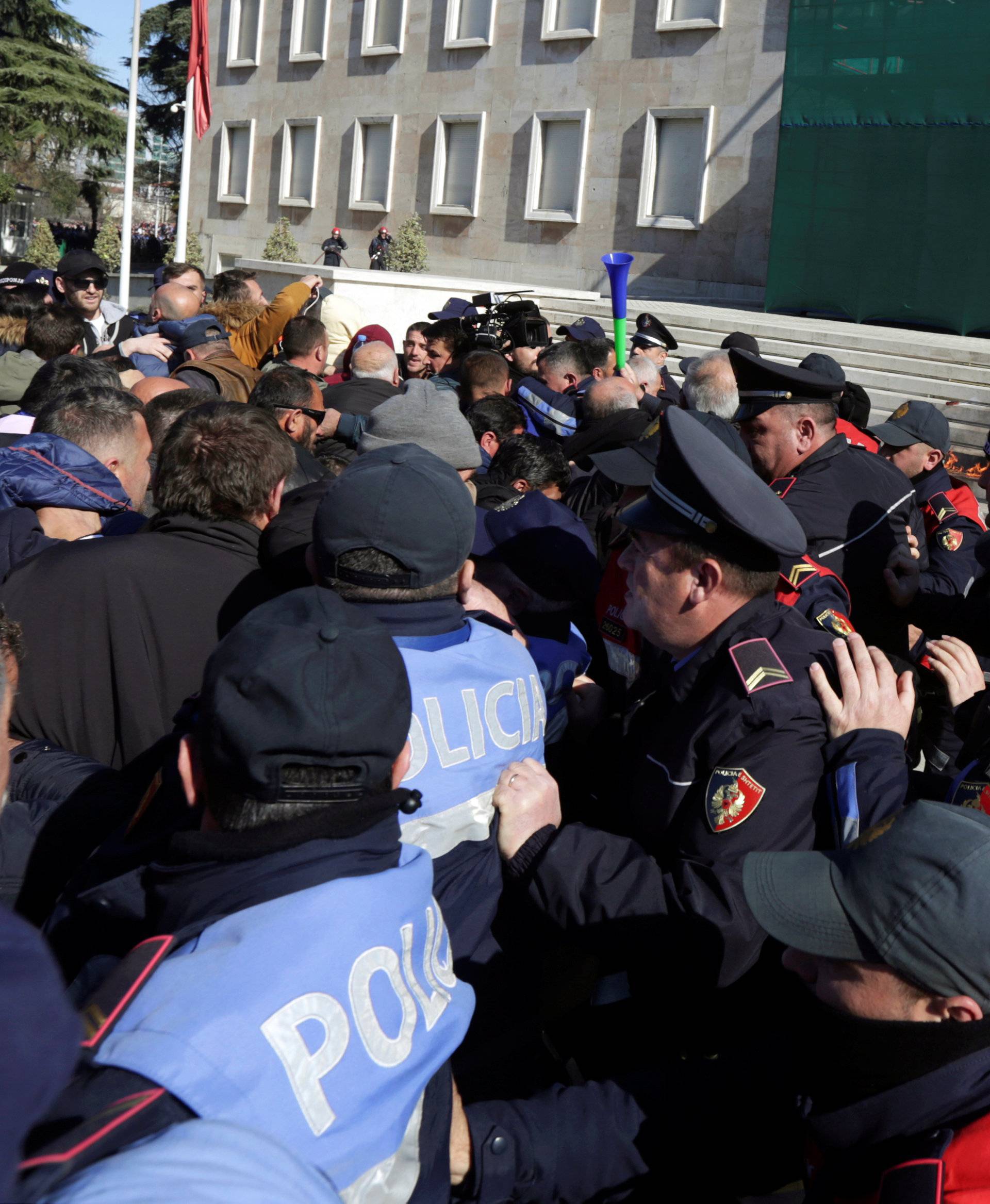 Police surrounds supporters of the opposition party protesting in front of a government building that houses the office of Prime Minister Edi Rama in Tirana